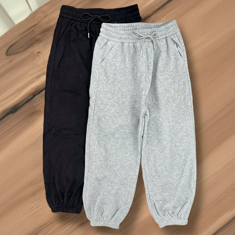 Black and grey sweatpants on a wooden surface