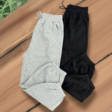 Grey and black sweatpants on a wooden surface