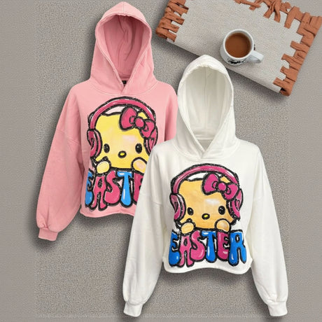 Pink and white hoodies with cartoon character and 'Easter' text on a gray surface