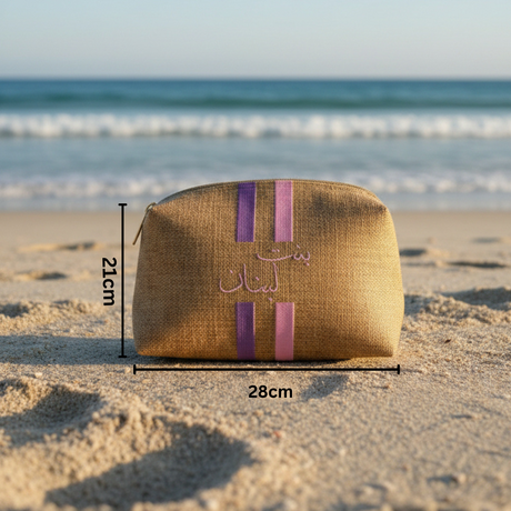 Brown pouch with purple stripes on a sandy beach