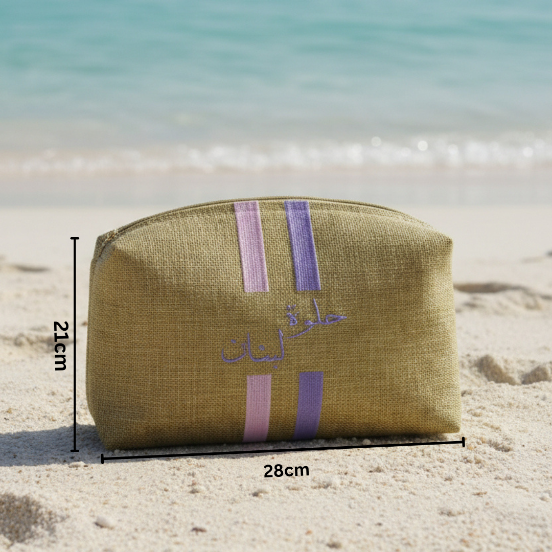 Beige pouch with purple stripes on a sandy beach