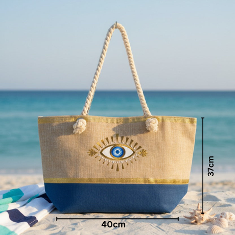 Beach bag with eye design on a sandy beach with ocean view