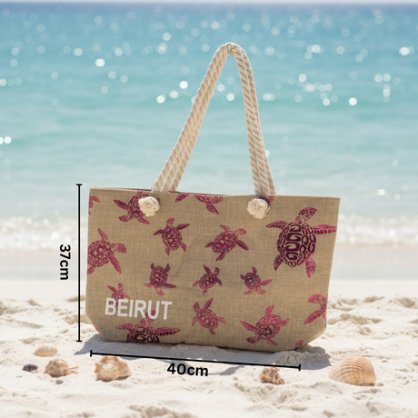 Beach bag with turtle design and 'Beirut' text on a sandy beach with ocean background
