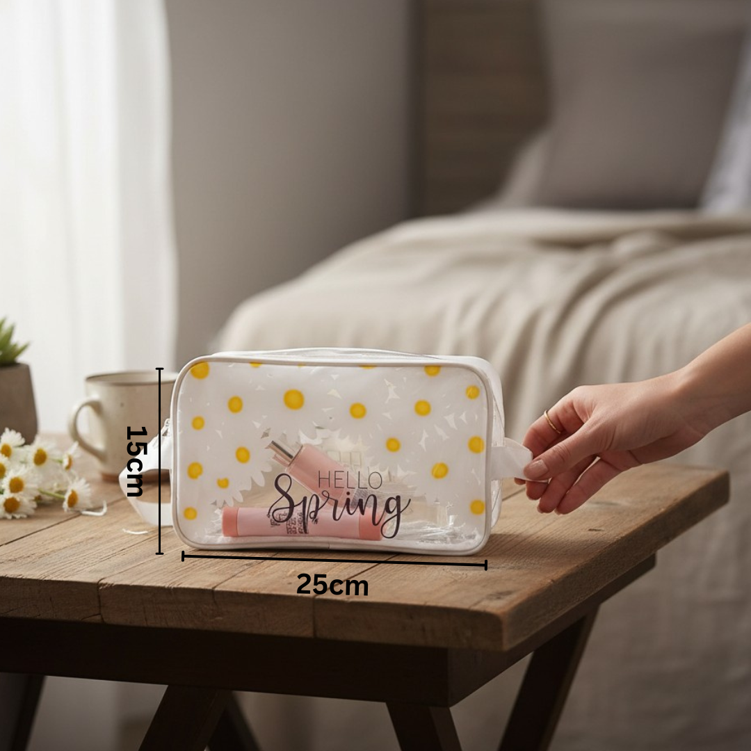 Clear pouch with yellow polka dots and 'Hello Spring' text on a wooden table, held by a hand.