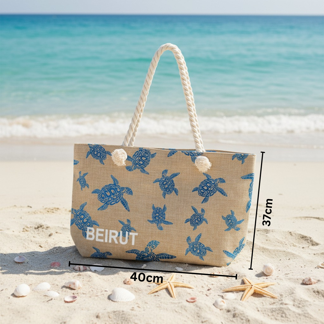 Beach bag with turtle pattern on sand and ocean background