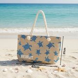 Beach bag with turtle pattern on sand and ocean background