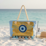 Beach bag with rope handle on a sandy beach with ocean view, featuring measurements.