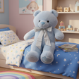 Powder blue seated teddy with a silver glitter neck bow on a star print duvet