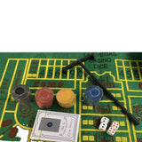 Green felt craps layout with chip stacks, a croupier stick, two dice and a sealed card deck