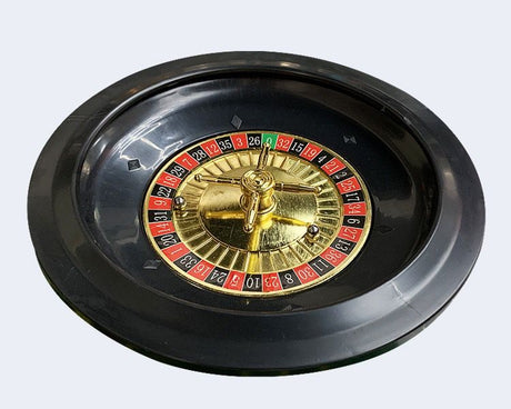 Close up of the black and gold roulette wheel with its red, black and green number ring