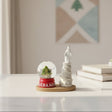 Our Lady of Lebanon tower statue beside a cedar tree globe on a red base, on a wooden tray