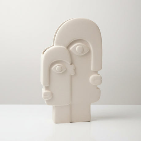 Twin arch ceramic face vase empty on a white studio sweep, both sculpted profiles visible