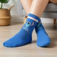 Kids royal blue crew socks with a pink stripe cuff and a smiling blue Stitch print, worn on feet