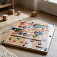Wooden alphabet magnetic maze with round coloured letter discs and a blue magnetic pen