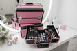 Pink quilted aluminium makeup cases, one open with four fold out trays of cosmetics