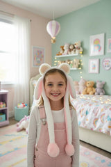 White plush animal ear headband with pale pink inner ears worn by a smiling young girl