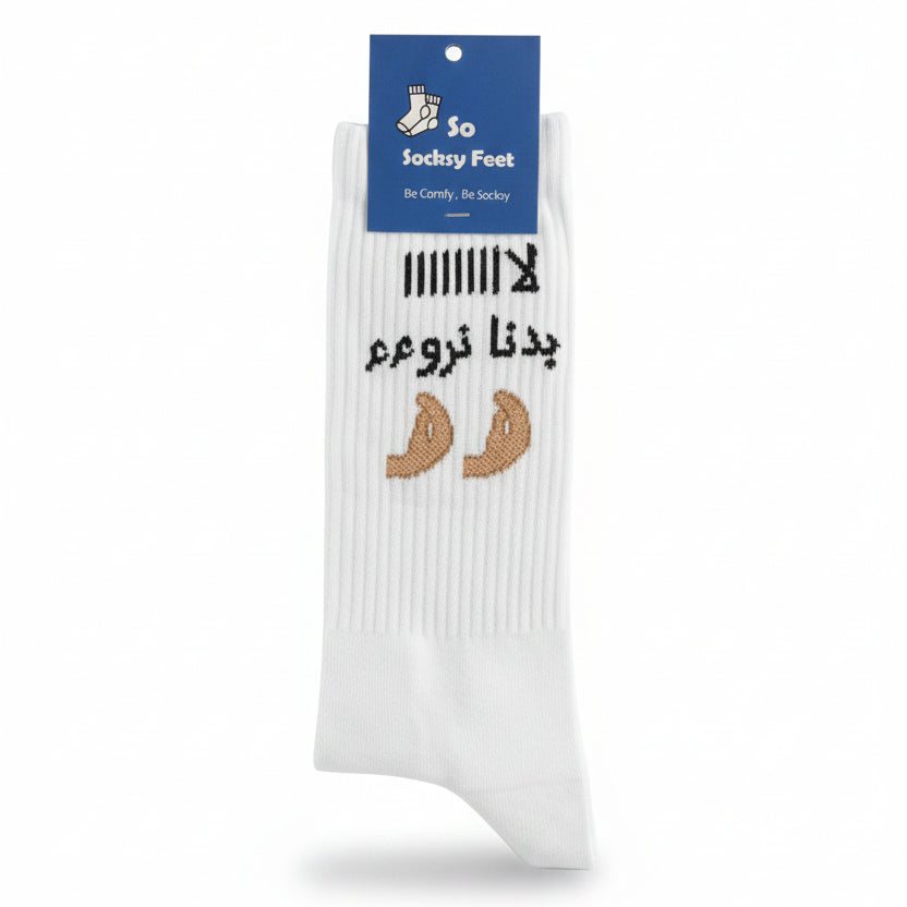 White crew sock with black Arabic lettering and two tan knitted motifs