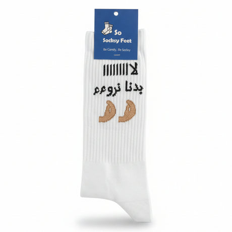 White crew sock with black Arabic lettering and two tan knitted motifs
