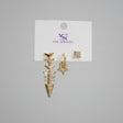 Gold arrow earrings on a jewelry branded card against a grey background