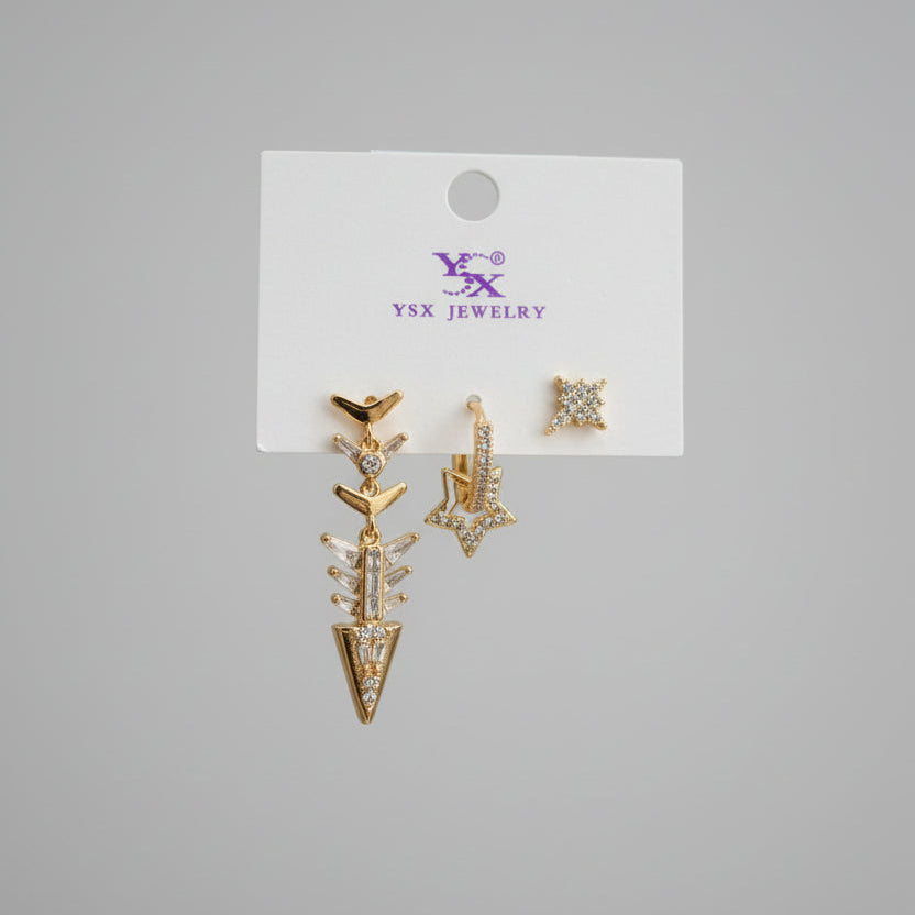 Gold arrow earrings on a jewelry branded card against a grey background