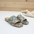 Colorful patterned slippers on a white floor and a wooden background