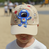 Beige kids baseball cap with a blue astronaut patch and planet prints, worn by a boy outdoors