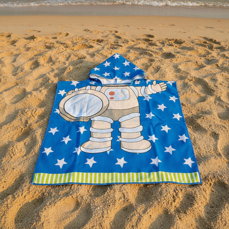 Blue astronaut poncho towel with a spacesuit print and green striped hem flat lay on sand