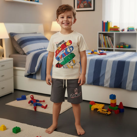 Boy in a bedroom wearing a cream Avengers tee and grey shorts, casual boys set for summer