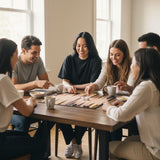 Group gathered round a backgammon board mid game with mugs on the table