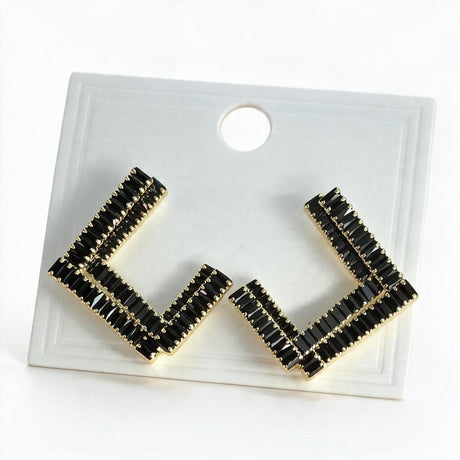 Pair of black baguette crystal open square earrings with gold edging on a white display card