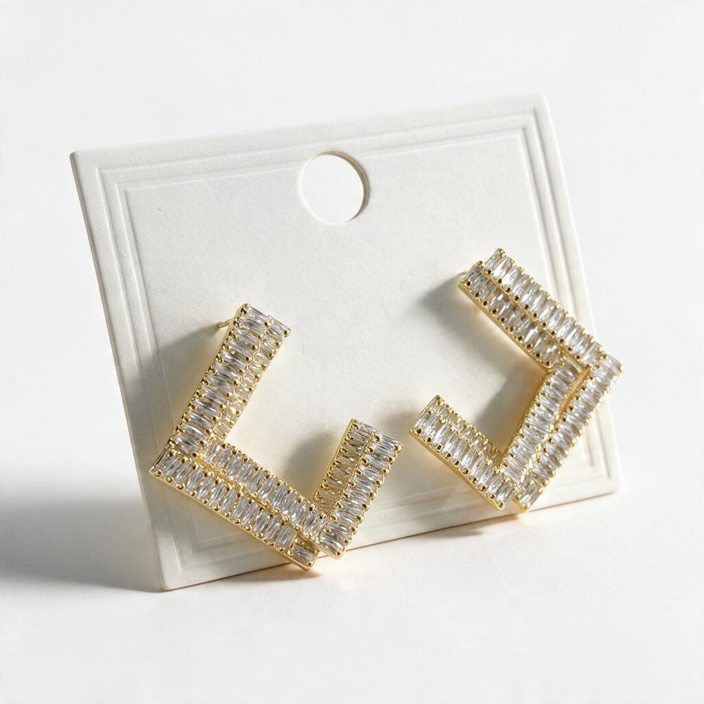 Gold open square earrings with double rows of clear baguette stones on a display card