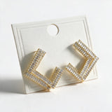 Gold open square earrings with double rows of clear baguette stones on a display card