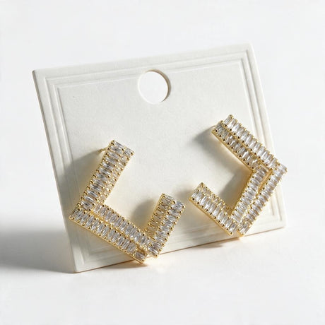 Gold open square earrings with double rows of clear baguette stones on a display card