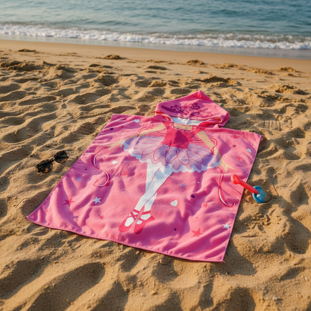 Pink beach towel with fairy design on sandy beach