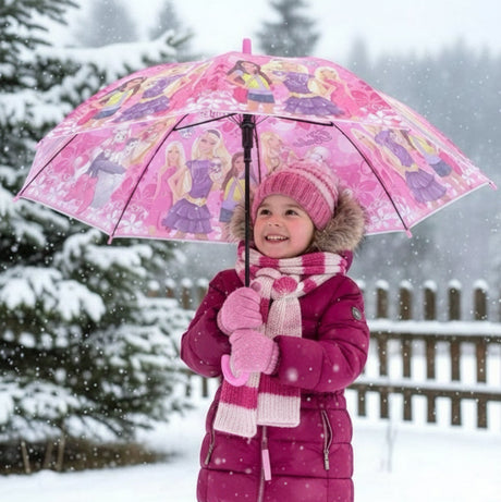 Girl in snow holding an open pink Barbie kids umbrella with a doll print canopy