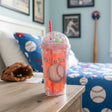 Coral red tumbler with a bead filled dome lid, red straw and a baseball print