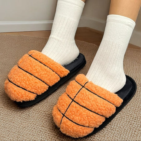 Orange basketball slippers with black lines worn indoors on a carpeted floor