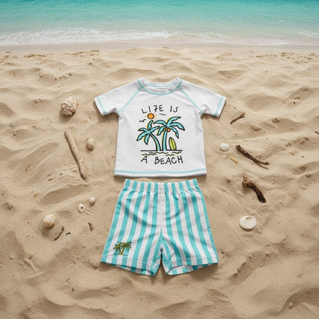 A children's two-piece beach outfit, featuring a white short-sleeve rash guard with a palm tree graphic, paired with mint-and-white striped shorts