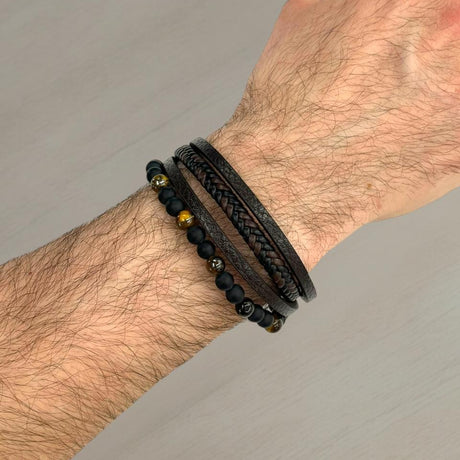 Brown leather and gold bead bracelet stack worn on a wrist