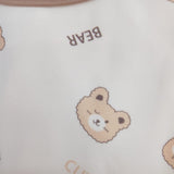 Close up of the teddy bear face print with BEAR lettering on cream pyjama fabric