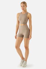 Woman wearing a beige athletic outfit on a white background