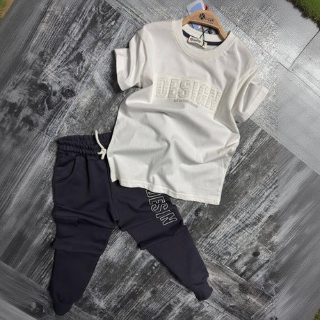 Cream embossed print tee and navy cargo joggers, boys two piece set laid flat