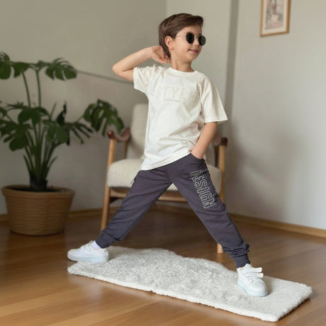 Boys set with a cream embossed print tee and dark navy cargo joggers, full length view