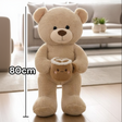 Beige smooth pile teddy bear with a latte mug plush, a heart drawn in its foam