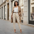 Woman wearing a beige trench coat and pants on a city street