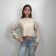 Oatmeal chunky knit crop sweater with long sleeves, worn with low rise jeans