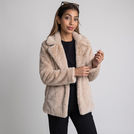 Beige teddy faux fur coat with wide lapels over a black top