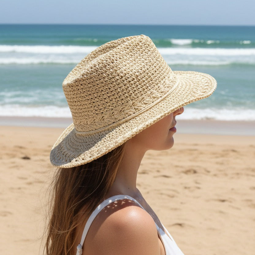 Beige crochet weave hat with a pinched fedora crown, worn facing the waves