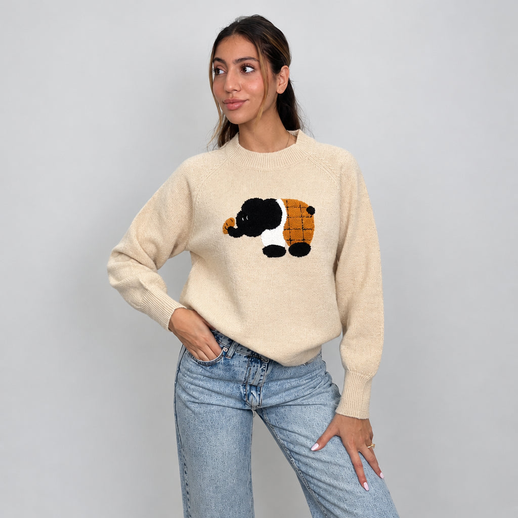 Beige elephant patch sweater with raglan sleeves, one hand on hip