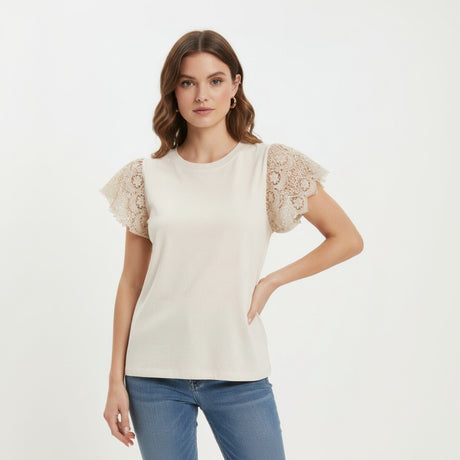 Woman wearing a beige blouse with lace sleeves on a white background